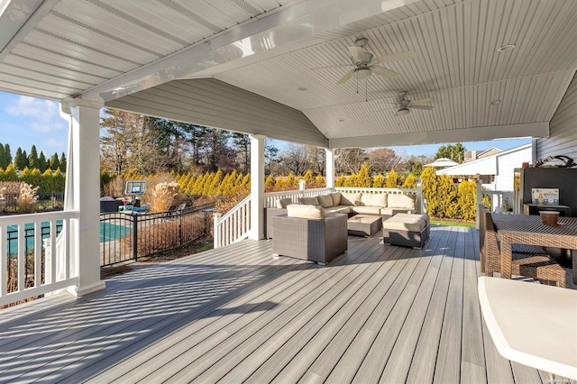 wooden deck with a pool, ceiling fan, and outdoor lounge area