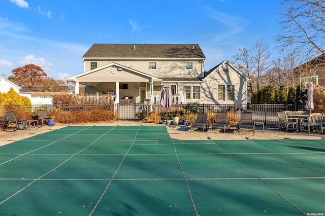 back of house featuring a covered pool and a patio area