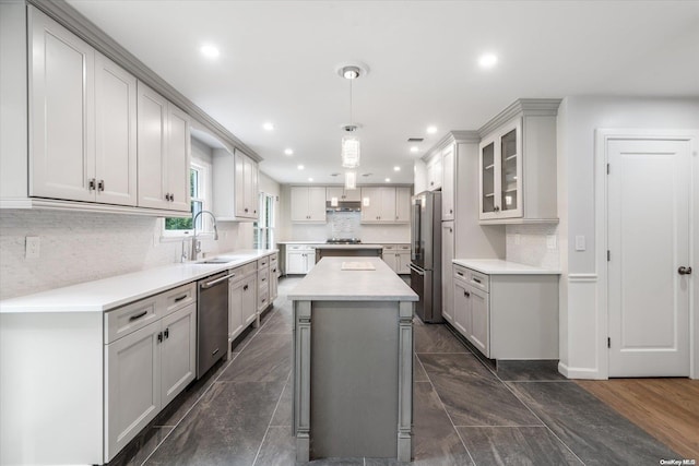 kitchen featuring sink, stainless steel appliances, dark hardwood / wood-style floors, pendant lighting, and a kitchen island