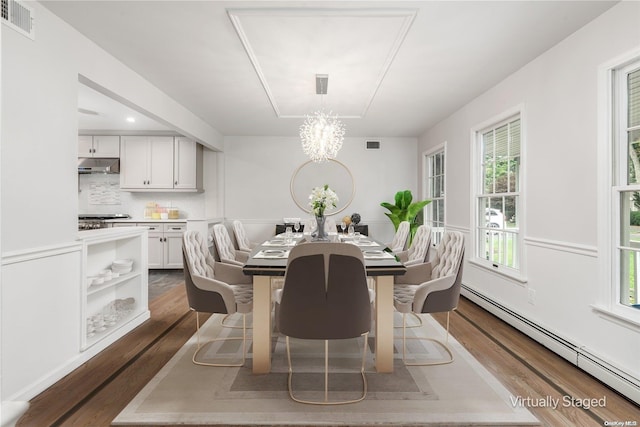 dining area featuring a chandelier, dark hardwood / wood-style floors, and baseboard heating