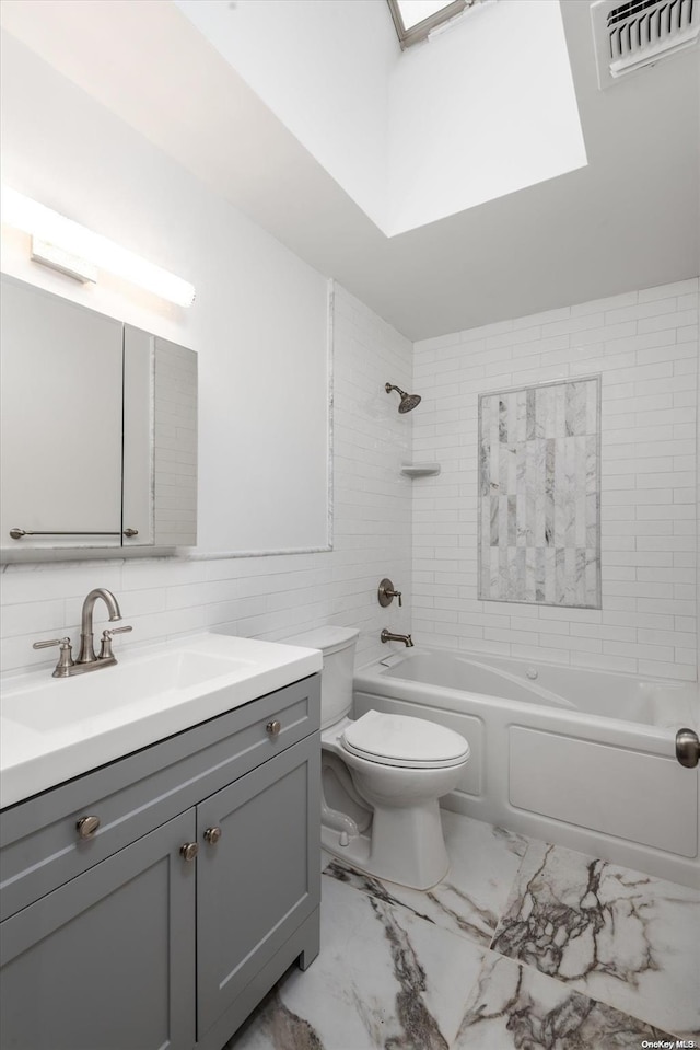 full bathroom featuring vanity, tiled shower / bath combo, tasteful backsplash, and toilet