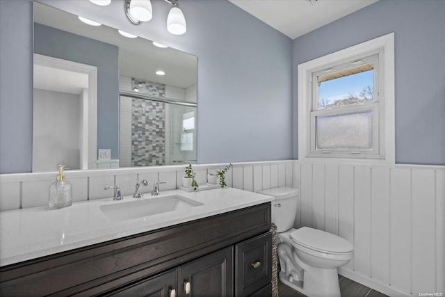 bathroom featuring vanity, an enclosed shower, and toilet