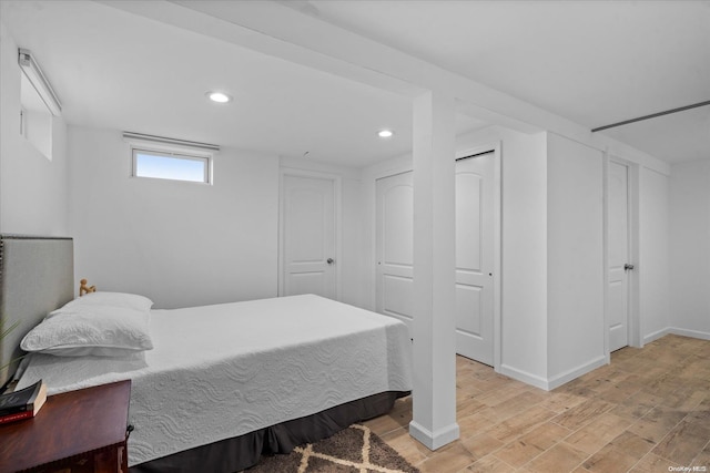 bedroom featuring light hardwood / wood-style flooring and two closets