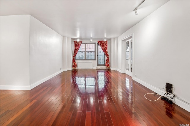 spare room featuring wood-type flooring and rail lighting