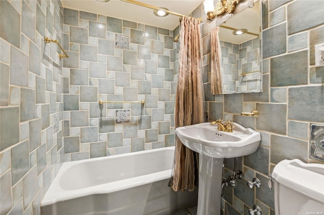 bathroom featuring shower / bathtub combination with curtain, toilet, and tile walls