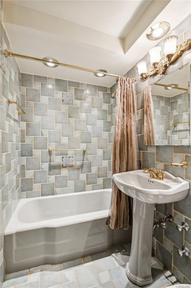 bathroom with shower / bath combination with curtain, tasteful backsplash, and tile walls