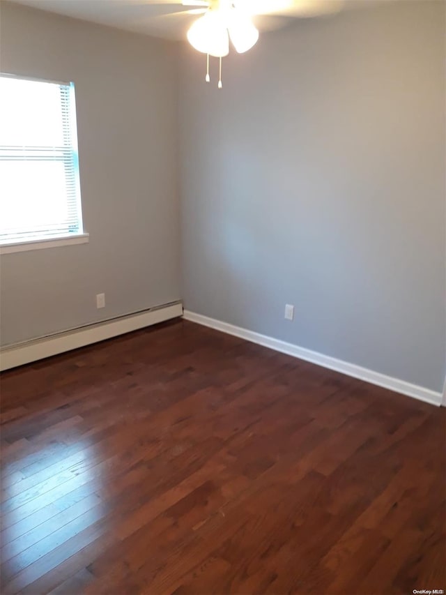 empty room featuring ceiling fan, dark wood-type flooring, and a baseboard radiator