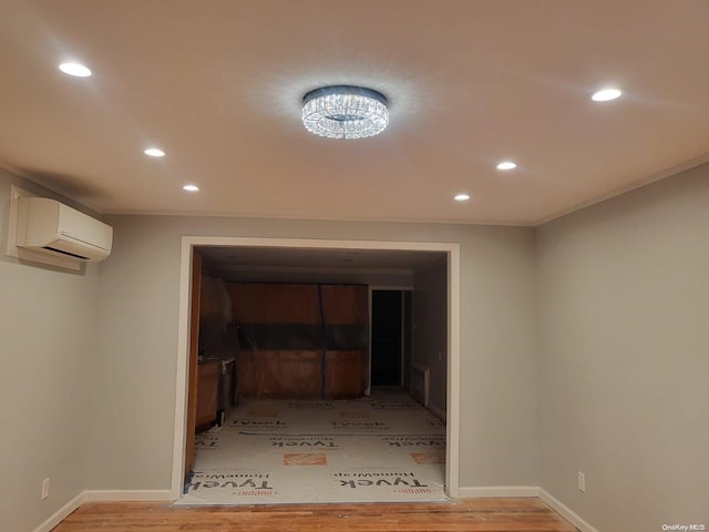 hall with a wall mounted air conditioner, light hardwood / wood-style floors, and crown molding