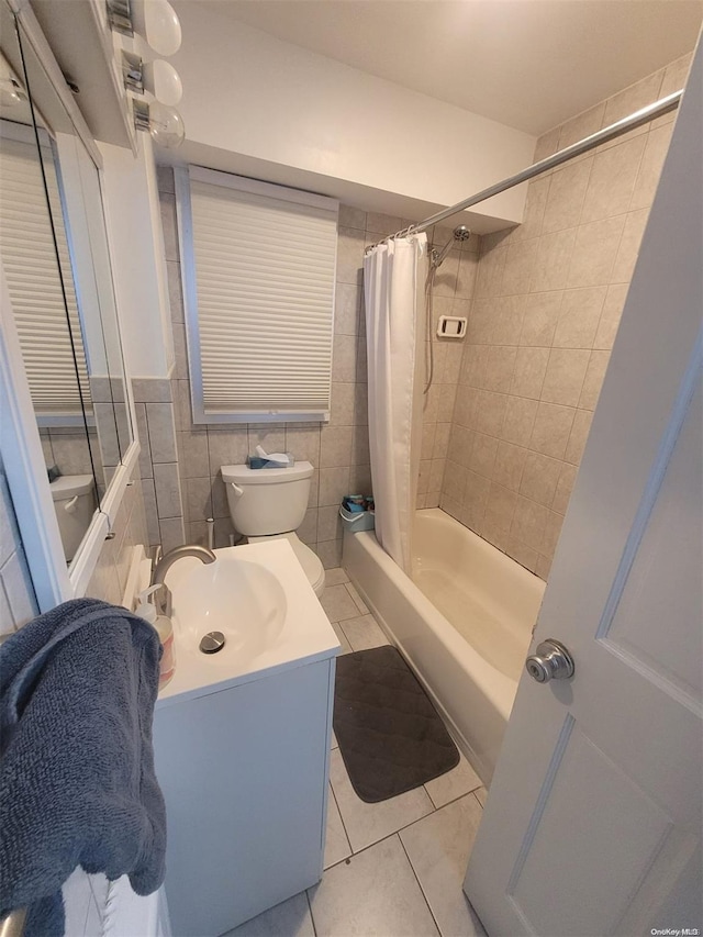 full bathroom featuring shower / bath combo, tile patterned floors, toilet, vanity, and tile walls