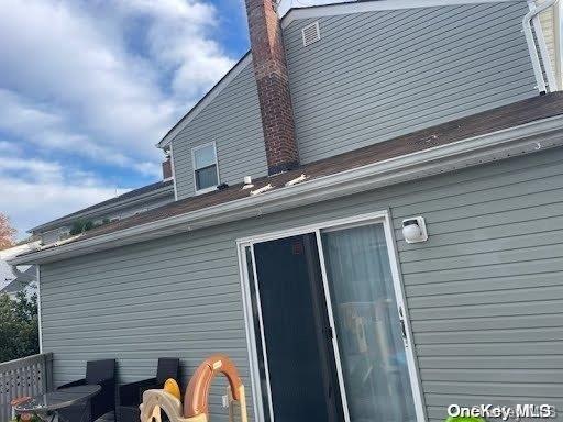 574 Lincoln St, Cedarhurst, NY 11516 - view of side of property featuring a chimney