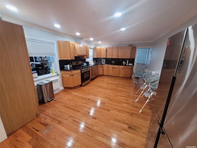 574 Lincoln St, Cedarhurst, NY 11516 - kitchen with appliances with stainless steel finishes, ornamental molding, light brown cabinets, light wood finished floors, and dark countertops