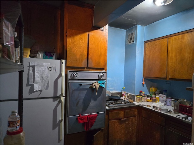 kitchen with white fridge and stainless steel gas cooktop