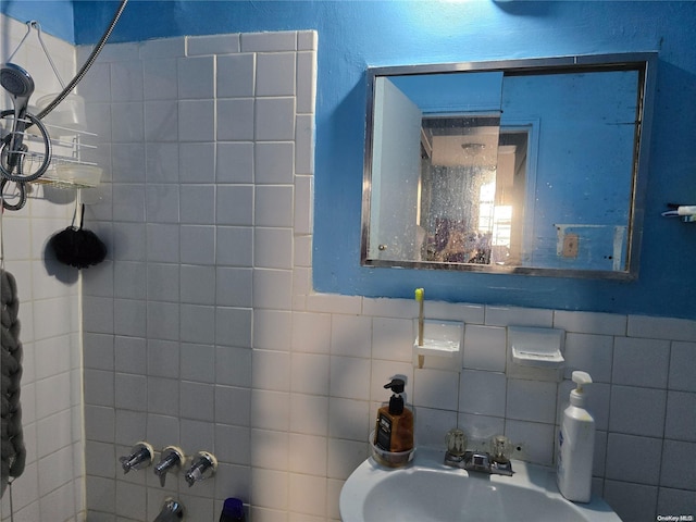 bathroom featuring tiled shower / bath, tile walls, and sink