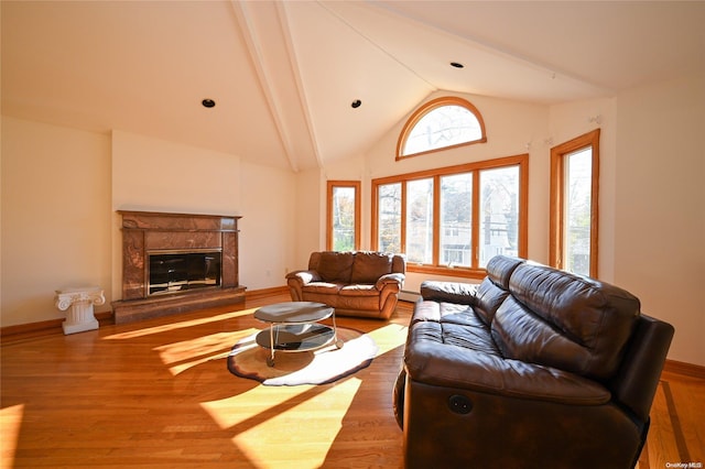 living room featuring vaulted ceiling with beams, hardwood / wood-style floors, and a fireplace