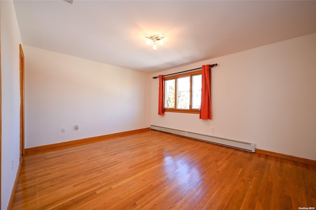 unfurnished room featuring light hardwood / wood-style floors and baseboard heating