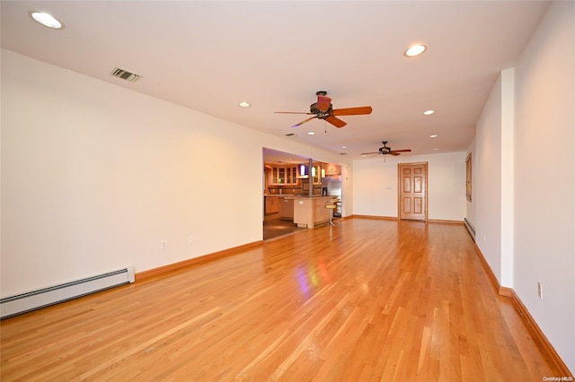 unfurnished living room with a baseboard radiator and light hardwood / wood-style floors