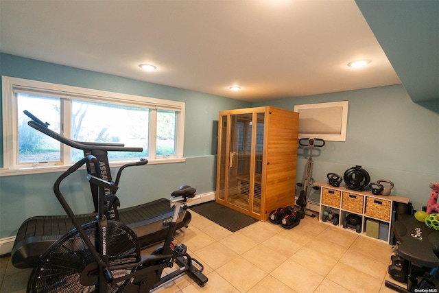 exercise room with a wealth of natural light and light tile patterned flooring