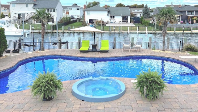 view of swimming pool with a patio area and a water view