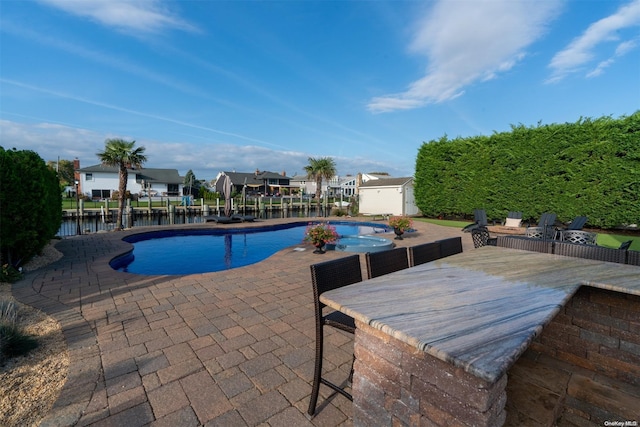 view of swimming pool with a water view and a patio