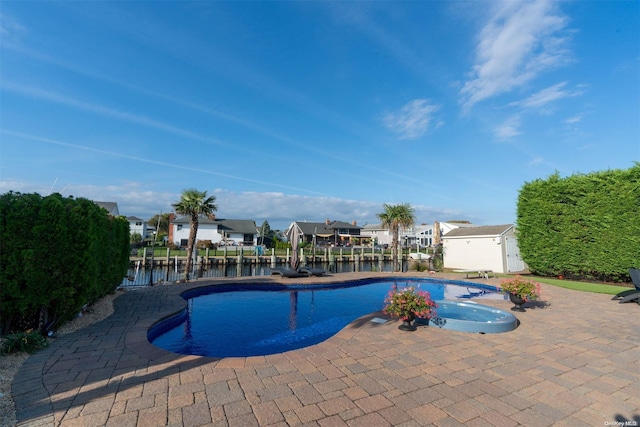 view of swimming pool featuring a water view and a patio