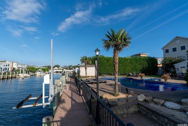 dock area featuring a water view and a fenced in pool