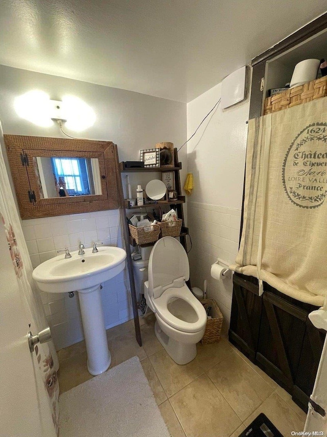 bathroom featuring tile patterned flooring, sink, toilet, and tile walls