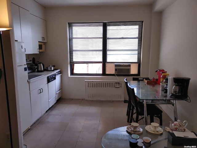 99-60 63rd Rd Unit 7R, Rego Park, NY 11374 - kitchen featuring radiator heating unit, white cabinets, light countertops, and freestanding refrigerator