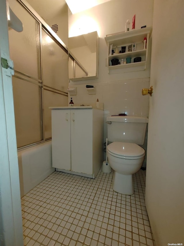 full bathroom with backsplash, tile patterned floors, vanity, shower / bath combination with glass door, and toilet