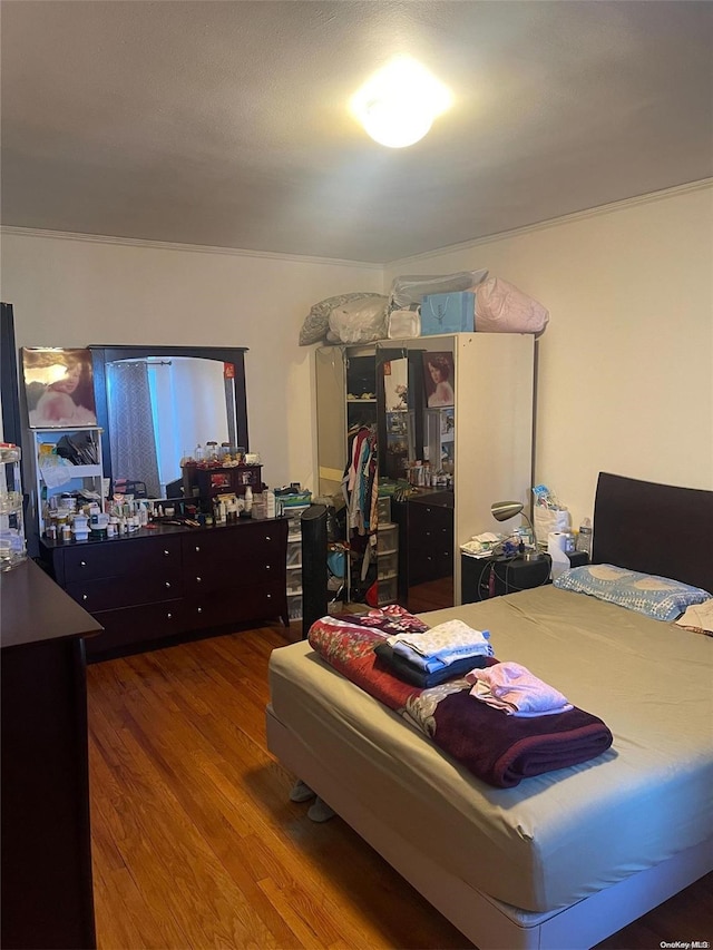 bedroom with hardwood / wood-style flooring and crown molding