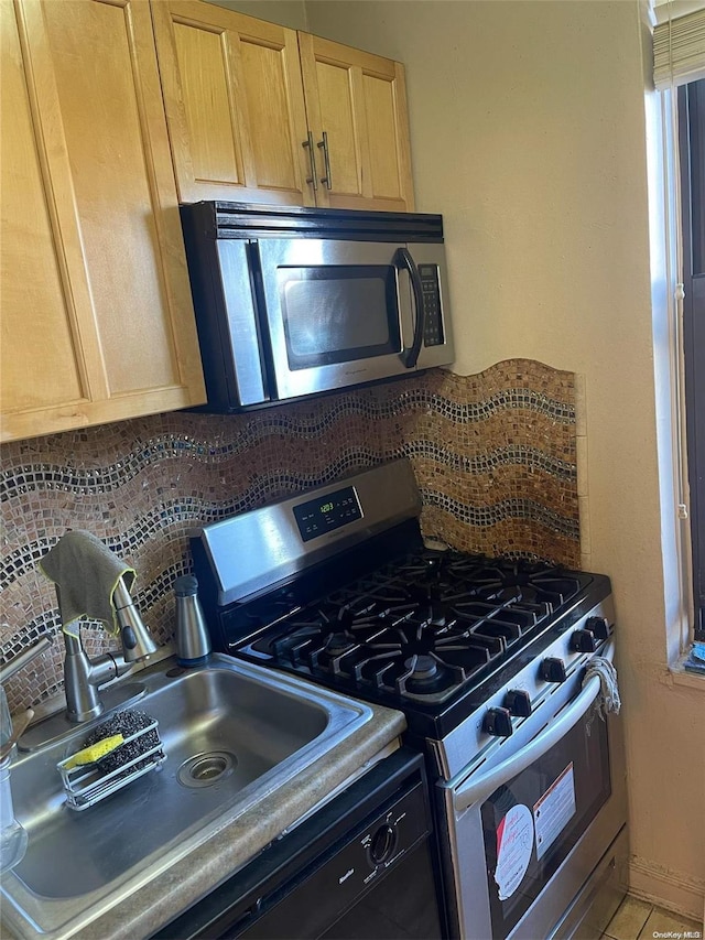 kitchen featuring decorative backsplash, appliances with stainless steel finishes, light brown cabinets, and sink