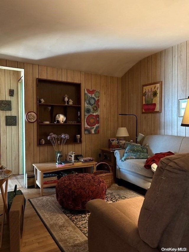 living area with wood walls, light wood-type flooring, and built in features