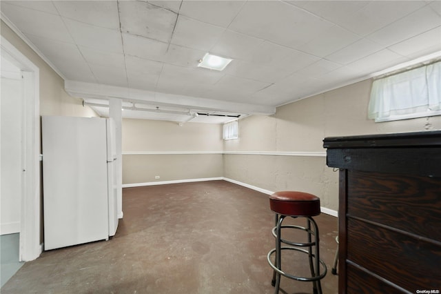 basement with indoor bar and white refrigerator