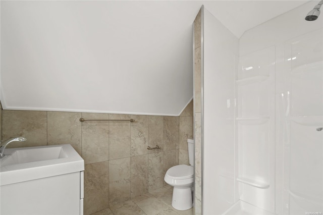 bathroom with tile patterned flooring, vanity, tile walls, and toilet