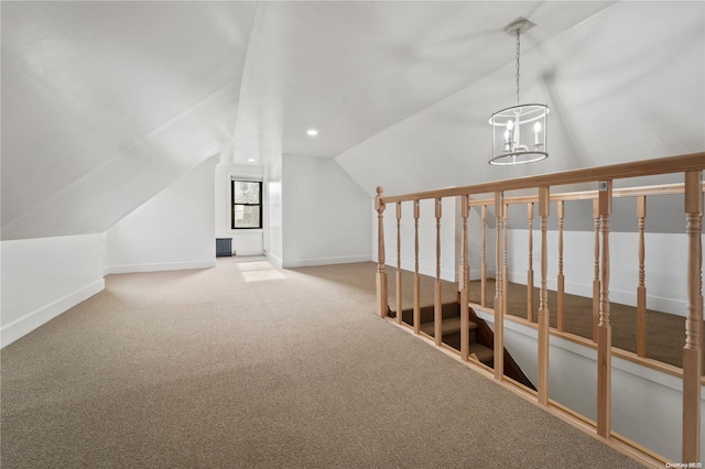 additional living space featuring carpet floors, vaulted ceiling, and a notable chandelier