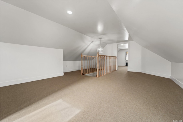 bonus room with carpet flooring and vaulted ceiling