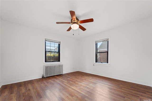 spare room featuring radiator heating unit, hardwood / wood-style flooring, and ceiling fan