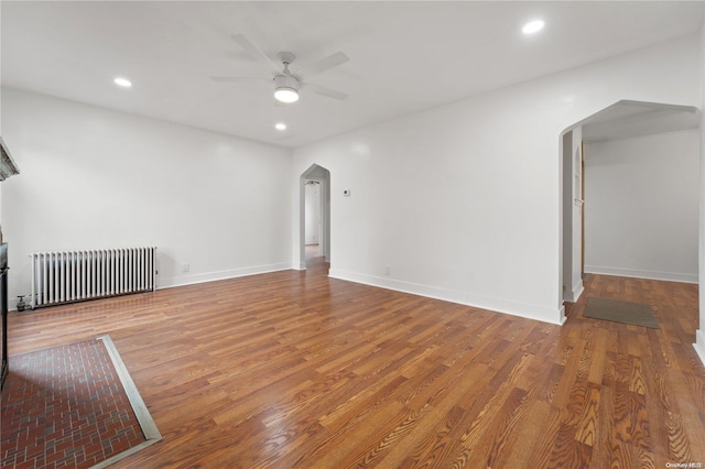 interior space with hardwood / wood-style flooring, radiator, and ceiling fan