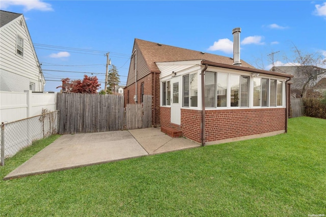 rear view of house featuring a patio area and a yard