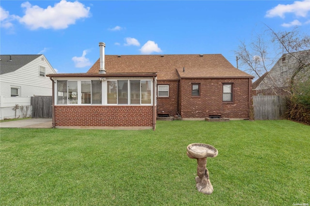 back of house featuring a sunroom, a yard, and a patio