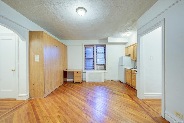 bonus room with cooling unit, a textured ceiling, and light wood-type flooring