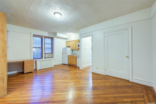 unfurnished living room featuring a textured ceiling, light hardwood / wood-style flooring, and cooling unit