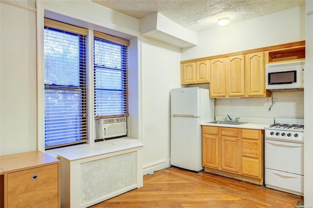 kitchen featuring a textured ceiling, white appliances, cooling unit, sink, and light hardwood / wood-style floors