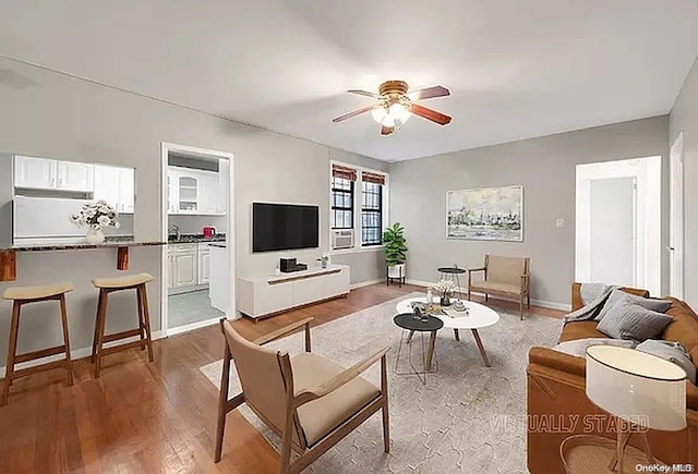 living room featuring ceiling fan and hardwood / wood-style flooring