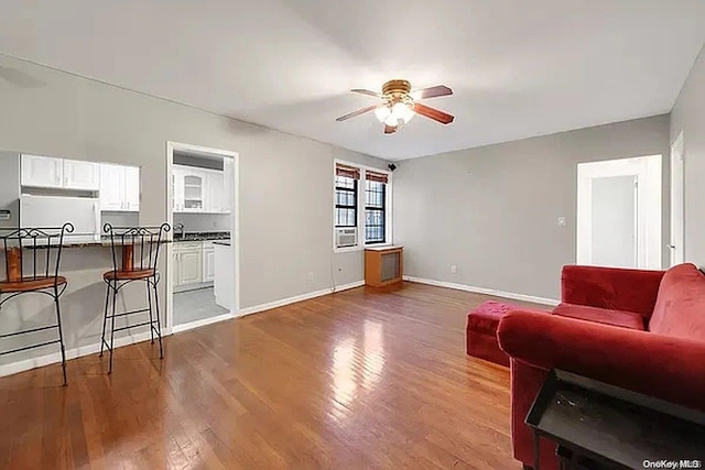 living room with dark hardwood / wood-style floors and ceiling fan