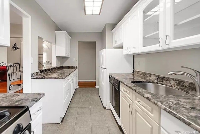 kitchen featuring dark stone countertops, sink, white cabinets, and black dishwasher