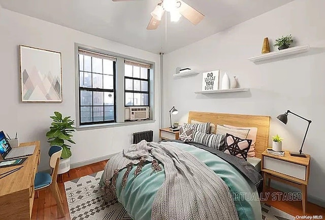 bedroom featuring ceiling fan, wood-type flooring, and radiator heating unit