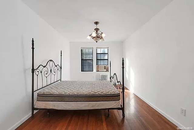 bedroom featuring hardwood / wood-style floors and an inviting chandelier