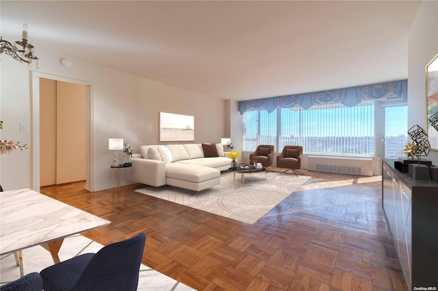 living room with parquet flooring, radiator, and a notable chandelier