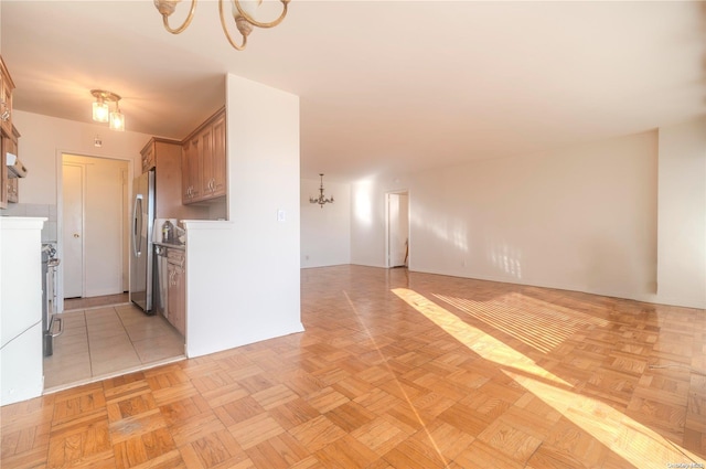 166-25 Powells Cove Blvd Unit 10G, Whitestone, NY 11357 - kitchen with a chandelier, freestanding refrigerator, brown cabinets, light countertops, and open floor plan