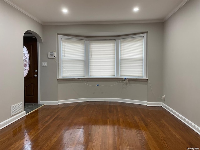 foyer entrance with crown molding and dark wood-type flooring